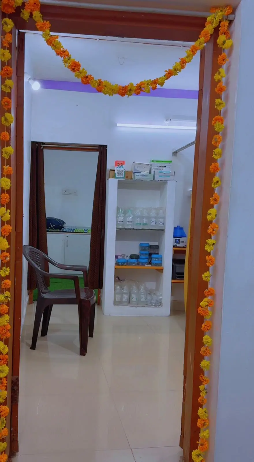 View through the front door: a chair, the medicine shelf and the doctor's room behind a curtain